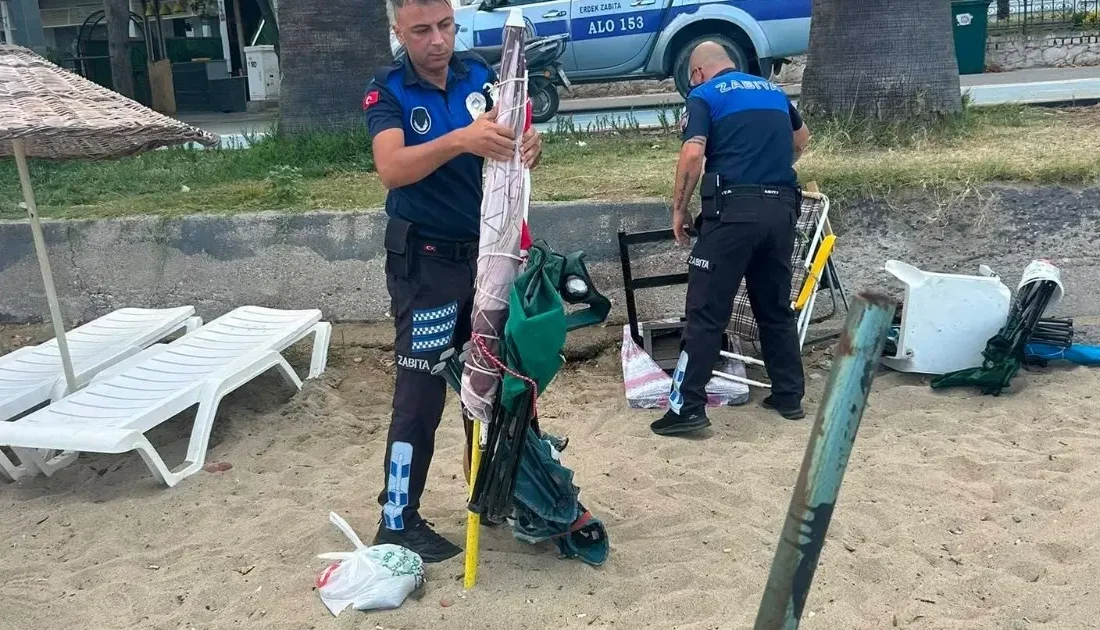 Erdek sahillerinde kumsal alanlara zincirlerle sabitlenen masa, sandalye ve şemsiyeler