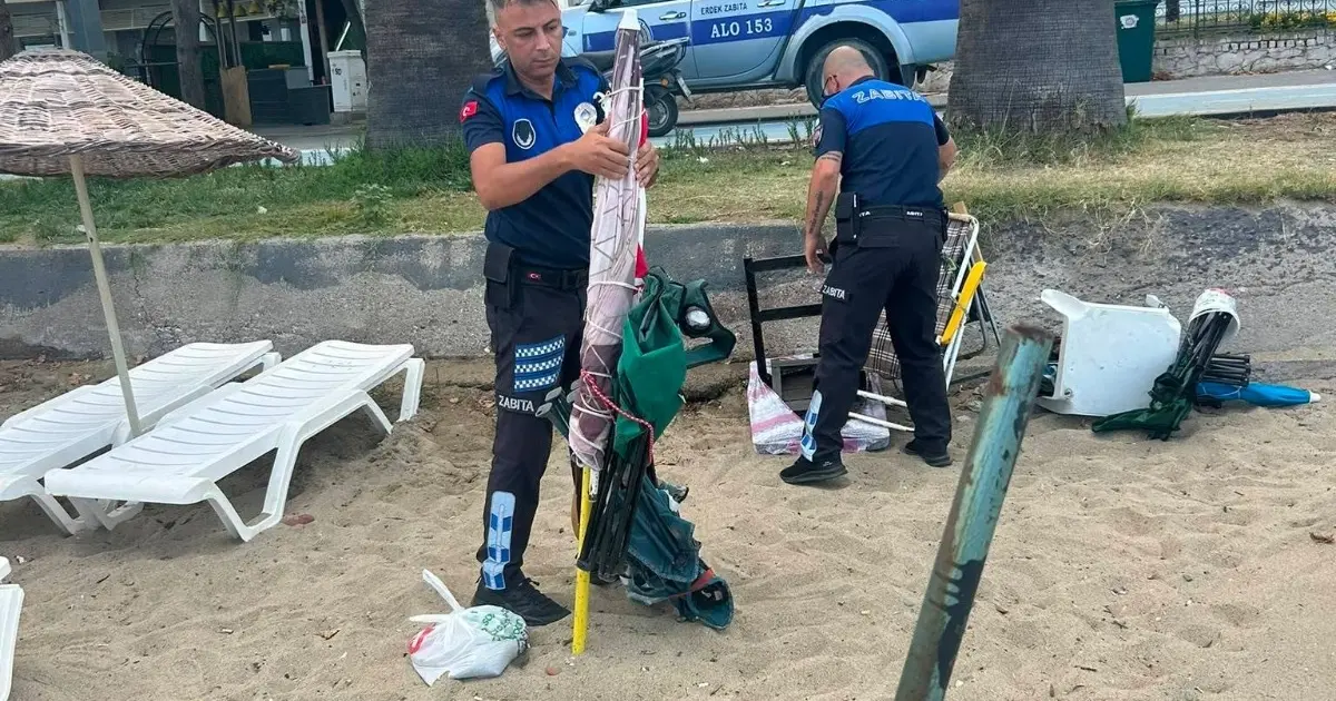 Erdek sahillerinde kumsal alanlara zincirlerle sabitlenen masa, sandalye ve şemsiyeler